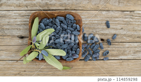 Blue Honeysuckle berries situated on rustic wooden table 114859298