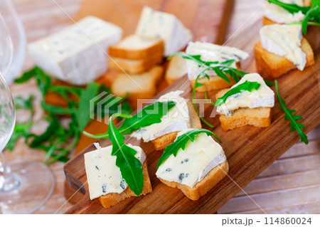 Blue cheese served with toast and arugula Blue cheese served with toast and arugula 114860024