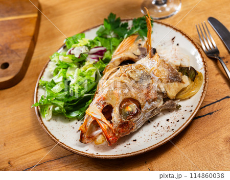 Roasted alfonsino fish head with crisp leafy salad 114860038