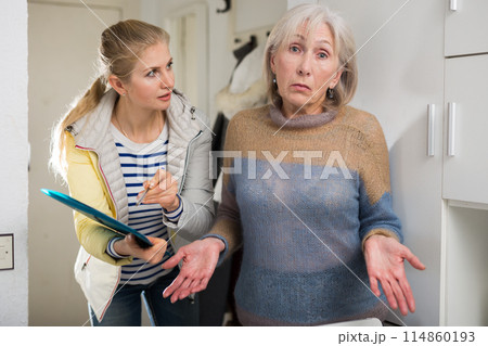 Surprised elderly woman cannot answer questions of interviewer at home Surprised elderly woman cannot answer questions of interviewer at home 114860193