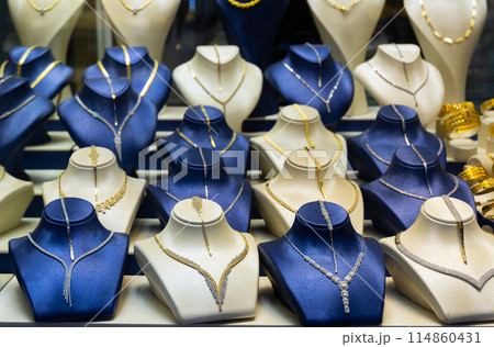 Assortment of jewelry is presented in brightly lit shop window. Assortment of jewelry is presented in brightly lit shop window. 114860431