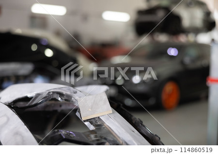 Sanded car par prepared for painting in auto repair shop Sanded car par prepared for painting in auto repair shop 114860519