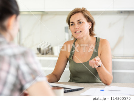 Woman manager tells girl client about specifics of design of microloan about benefits and advantages Woman manager tells girl client about specifics of design of microloan about benefits and advantages 114860570