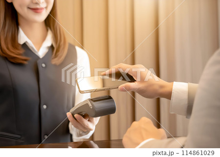 スマートフォンを使って非接触で支払いを行う女性 114861029
