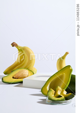 The white empty platform in rectangle shaped, decorated by yellow with green color of avocado and banana on white background. Both avocado and banana is rich in necessary nutrients for health 114863286