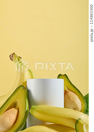 Frontal shot template photo for designing advertising of products made from natural fruit ingredients such as banana and avocado, which has many benefit for health and beauty, blank podium in center Frontal shot template photo for designing advertising of products made from natural fruit ingredients such as banana and avocado, which has many benefit for health and beauty, blank podium in center 114863300