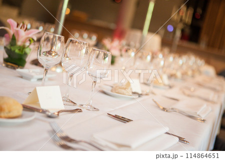 A beautiful table arrangement with glassware and flowers for a special and elegant occasion A beautiful table arrangement with glassware and flowers for a special and elegant occasion 114864651