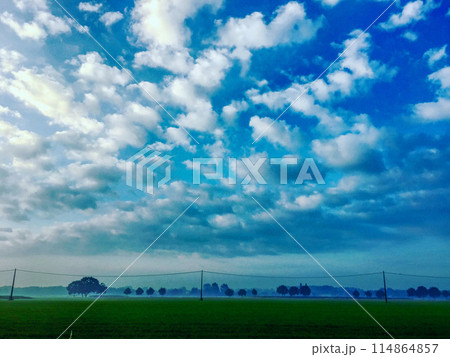 Serene Landscape with Blue Sky and Fluffy Clouds, illustrating natures beauty and tranquility Serene Landscape with Blue Sky and Fluffy Clouds, illustrating natures beauty and tranquility 114864857