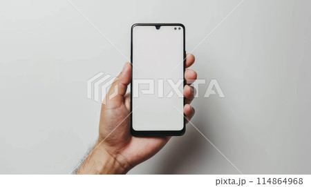 Man hand holding the black smartphone with blank screen on white background. Gadget with empty free space for mock up 114864968