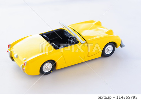 黄色の二人乗りのオープンカーで、気ままなドライブ旅行に出発するイメージ画像 114865795