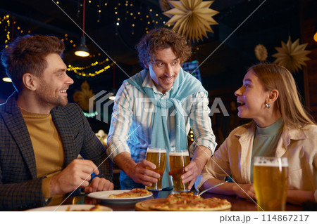 Closeup view of cheerful guy buying friends beer during rest in bar Closeup view of cheerful guy buying friends beer during rest in bar 114867217