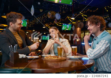 Friends eating pizza drinking beer while rest in pub 114867241
