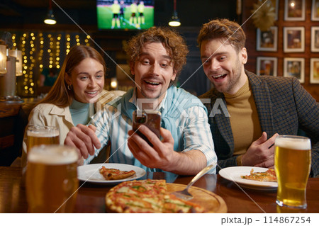 Young relaxed people looking into smartphone while rest in bar 114867254