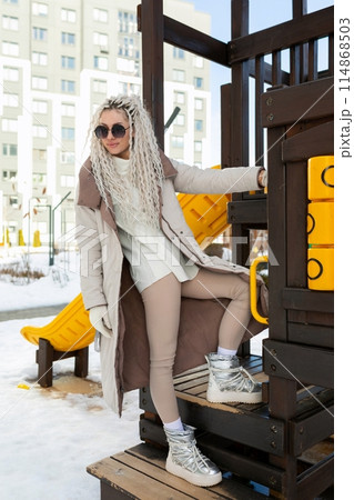 Woman Sitting on Top of a Wooden Structure 114868503