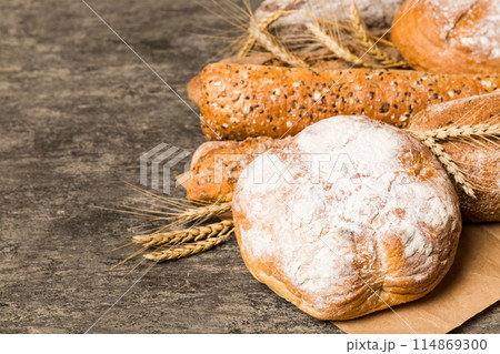 Homemade natural breads. Different kinds of fresh bread as background, perspective view with copy space Homemade natural breads. Different kinds of fresh bread as background, perspective view with copy space 114869300