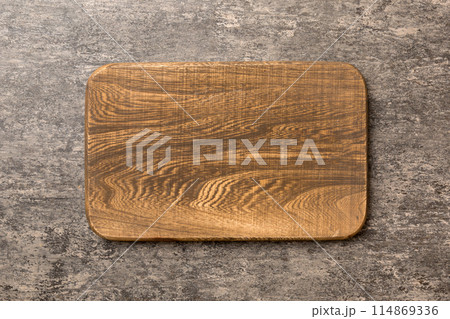 Top view of wooden cutting board on cement background. Empty space for your design Top view of wooden cutting board on cement background. Empty space for your design 114869336
