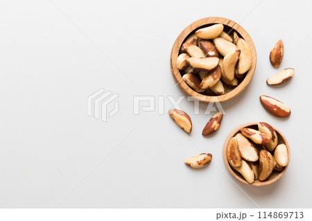 Fresh healthy Brazil nuts in bowl on colored table background. Top view Healthy eating bertholletia concept. Super foods Fresh healthy Brazil nuts in bowl on colored table background. Top view Healthy eating bertholletia concept. Super foods 114869713