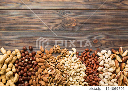different nuts frame background. Close up, top view, flat lay with vopy space. Walnut, pistachios, almonds, hazelnuts and cashews 114869803