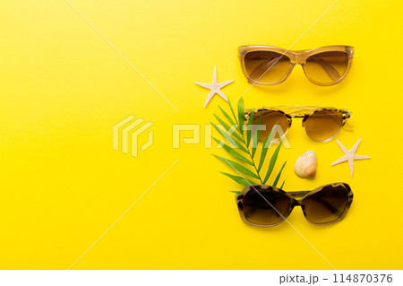 sunglasses with seashell lying on table background. Sunglasses on summer background. Top view flat lay with copy space for text 114870376