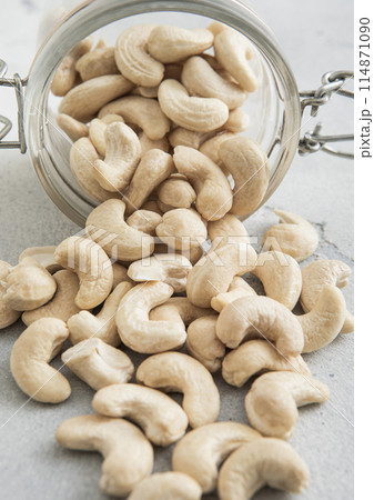 Raw healthy cashew nuts snack in glass jar on white kitchen table. Raw healthy cashew nuts snack in glass jar on white kitchen table. 114871090