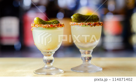 Shaken vodka and pickle juice with ice in a shot glass and garnished with small pickled cucumber and dill Shaken vodka and pickle juice with ice in a shot glass and garnished with small pickled cucumber and dill 114871402