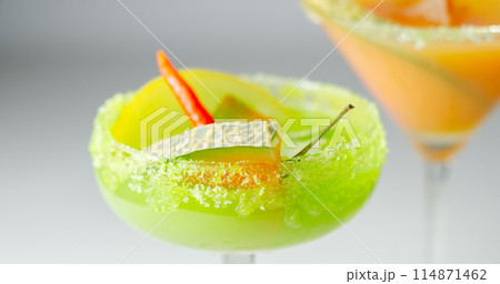 A holiday cocktail based on vodka, liqueur, fresh melon and red bird eye chilli, a refreshing drink prepared by a bartender A holiday cocktail based on vodka, liqueur, fresh melon and red bird eye chilli, a refreshing drink prepared by a bartender 114871462