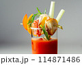 A glass of Bloody Mary drink with a celery spear and an orange slice on top 114871486