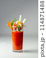 A glass of Bloody Mary drink with a celery spear and an orange slice on top 114871488