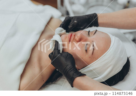 A girl at a cosmetologist does cosmetic procedures. Skin cleansing A girl at a cosmetologist does cosmetic procedures. Skin cleansing 114873146