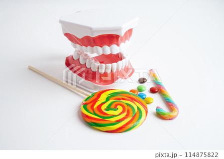 Tooth decay with sweet sugar candy, bad food for dental health care. Tooth decay with sweet sugar candy, bad food for dental health care. 114875822