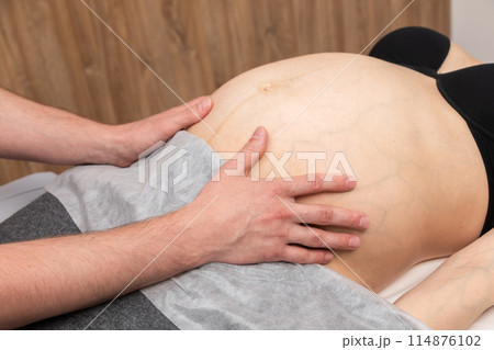 Pregnant Woman Receiving Osteopathic Belly Treatment Pregnant Woman Receiving Osteopathic Belly Treatment 114876102