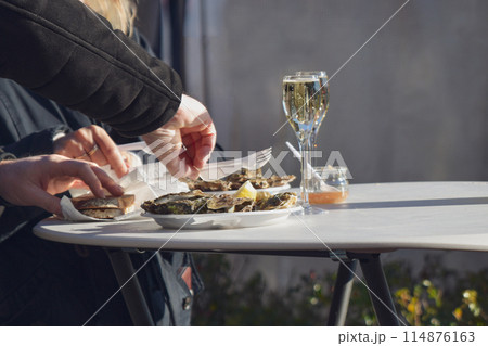 Woman eating fresh oysters at Christmas market in Paris 114876163
