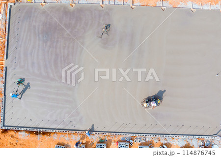 After poured with concrete is wet foundation mason labors finishing polished concrete using concrete polishing machines. 114876745