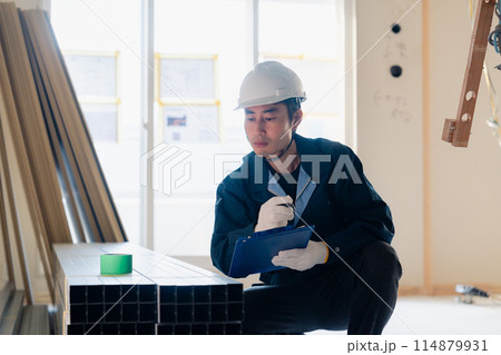建設現場で資材の確認をする大工 114879931