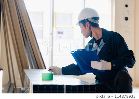 建設現場で資材の確認をする大工 建設現場で資材の確認をする大工 114879933