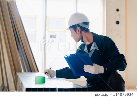 建設現場で資材の確認をする大工 114879934