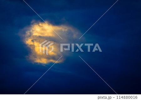 Radiant sunlight illuminating an isolated cloud at twilight Radiant sunlight illuminating an isolated cloud at twilight 114880016