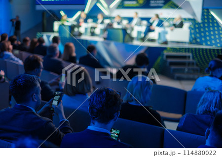 Business professionals attending a conference in a modern auditorium Business professionals attending a conference in a modern auditorium 114880022