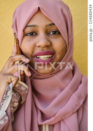 Digital Connection: Close-up Portrait of a Middle Eastern Teenage Muslim Girl Using Smartphone 114880434