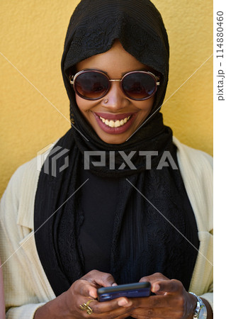 Digital Connection: Close-up Portrait of a Middle Eastern Teenage Muslim Girl Using Smartphone Digital Connection: Close-up Portrait of a Middle Eastern Teenage Muslim Girl Using Smartphone 114880460