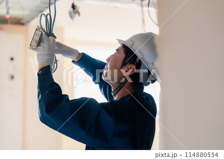 建築現場で配線工事をする電気工事士 114880534