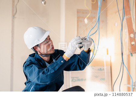 建築現場で配線工事をする電気工事士 114880537