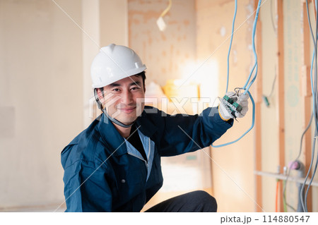 建築現場で配線工事をする電気工事士 114880547