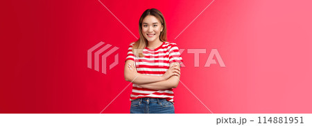 Friendly happy enthusiastic cute blond asian girl look camera smiling toothy white grin, cross arms chest self-soothing relaxed pose trying act normal talking stranger cafe queue, red background 114881951