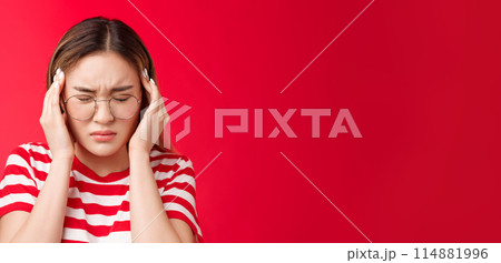 Close-up pressured distressed young asian woman grab head touch temples, frowning close eyes bend head suffering headache, feel terrible migraine, standing upset red background Close-up pressured distressed young asian woman grab head touch temples, frowning close eyes bend head suffering headache, feel terrible migraine, standing upset red background 114881996