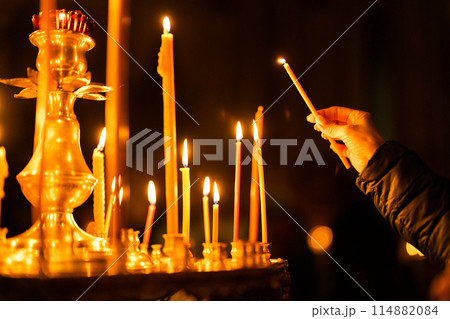 Many burning wax candles in the orthodox church or temple. 114882084