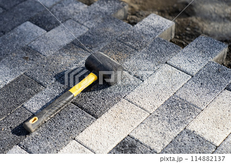 Garden brick pathway paving by professional paver worker. Repairing sidewalk. 114882137