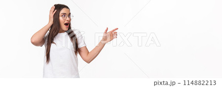 Waist-up portrait of surprised, astonished young brunette woman, 20s years, pointing and looking right, touch head cant believe she sees something so awesome, startled standing white background Waist-up portrait of surprised, astonished young brunette woman, 20s years, pointing and looking right, touch head cant believe she sees something so awesome, startled standing white background 114882213