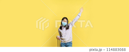 Full length shot happy asian woman going on vacation, tourist with suitcase posing cheerful, wearing medical face mask, yellow background Full length shot happy asian woman going on vacation, tourist with suitcase posing cheerful, wearing medical face mask, yellow background 114883088