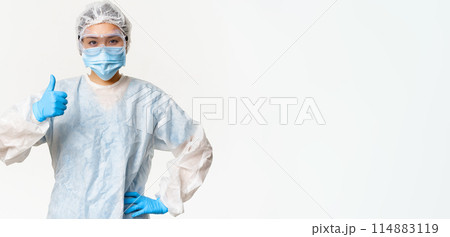 Asian female doctor or nurse wearing personal protective equipment and rubber gloves, medical face mask, showing thumbs up, vaccination and covid-19 campaign concept Asian female doctor or nurse wearing personal protective equipment and rubber gloves, medical face mask, showing thumbs up, vaccination and covid-19 campaign concept 114883119